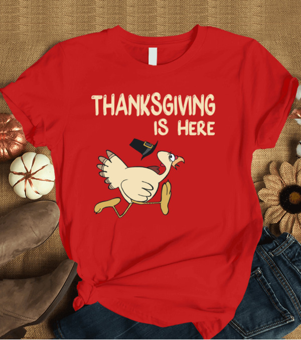 T-Shirt: Thanksgiving is Here Turkey with Pilgrim Hat on Red T-Shirt Thanksgiving is Here Turkey with Pilgrim Hat on Red T-Shirt