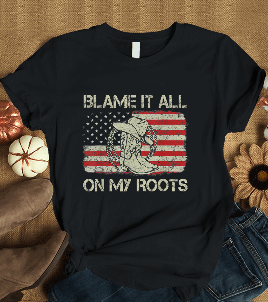 Blame It All On My Roots Cowboy Hat Boots American Flag Background T-Shirt